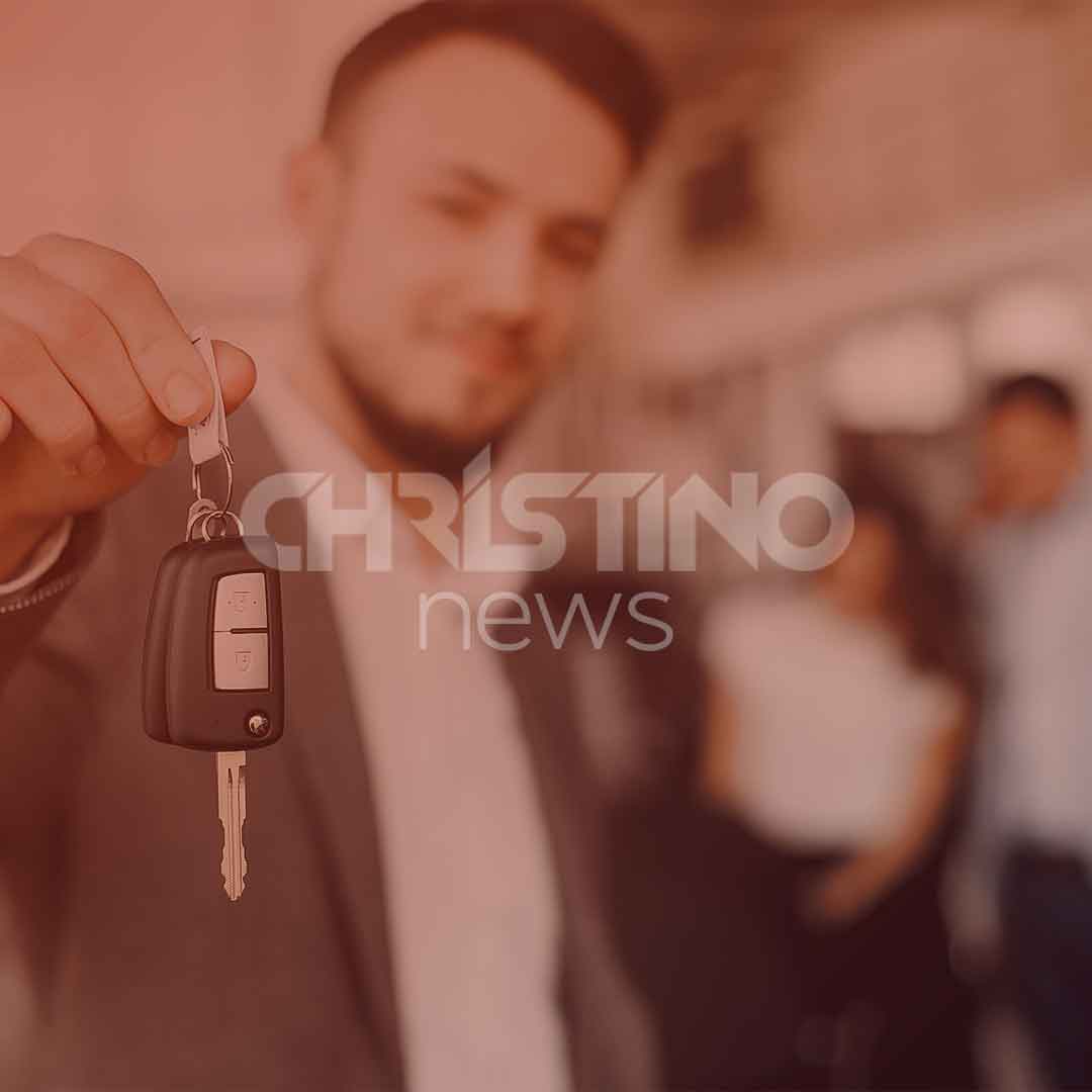 Homem segurando a chave de um carro, com pessoas olhando no fundo, simbolizando a conquista de seu carro 0km