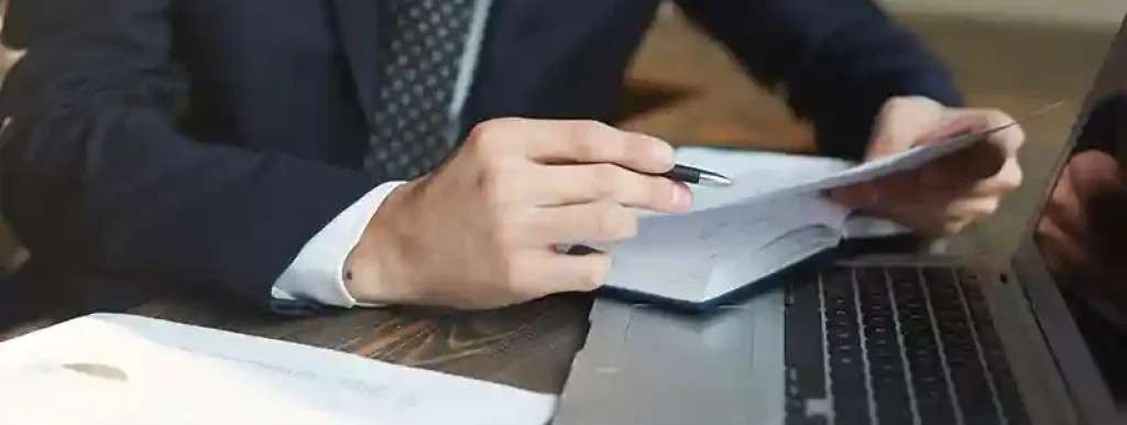 advogado-analisando-caderno-com-noteebok-e-papeis-ao-lado