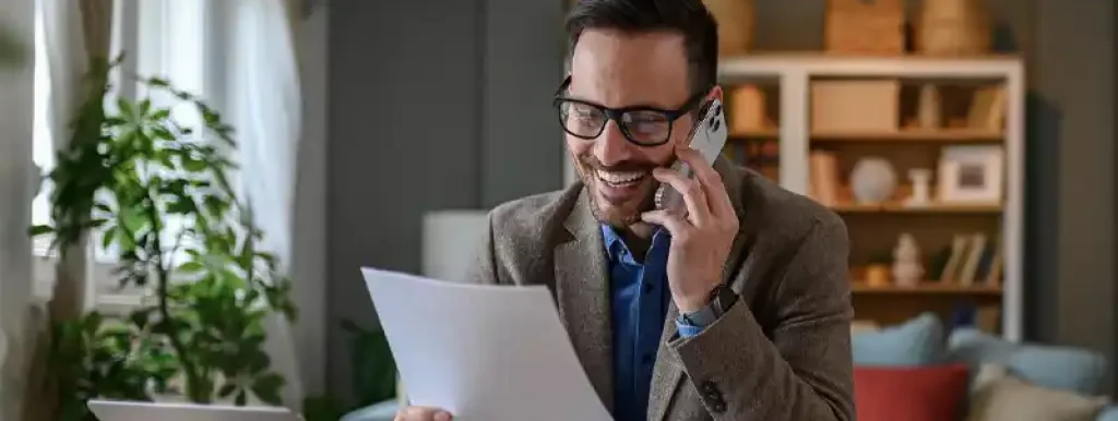 corretor-analisando-documentos-falando-no-seu-celular