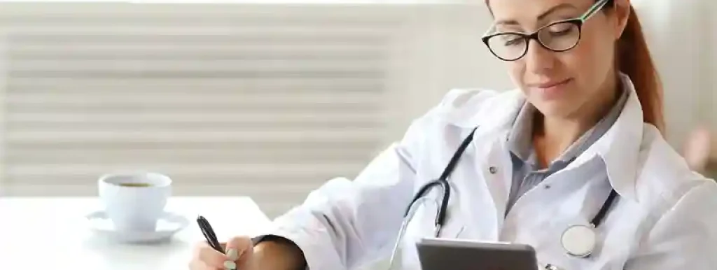 médica-analisando-suas-financas-utilizando-um-tablet-com-papeis-na-mesa